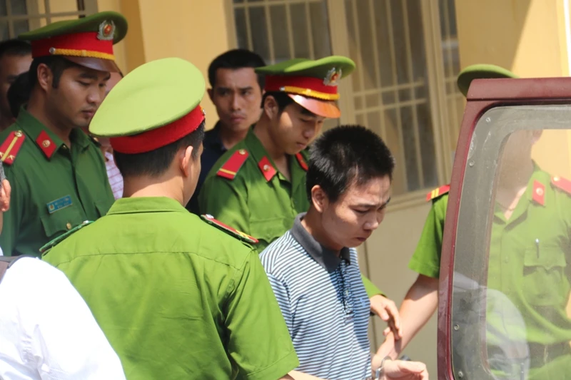 Bị cáo được dẫn lên xe đưa về trại giam. Ảnh HUY TRƯỜNG