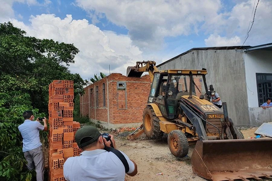 Lực lượng chức năng đang tháo dỡ những căn nhà xây sai phép. Ảnh: QN