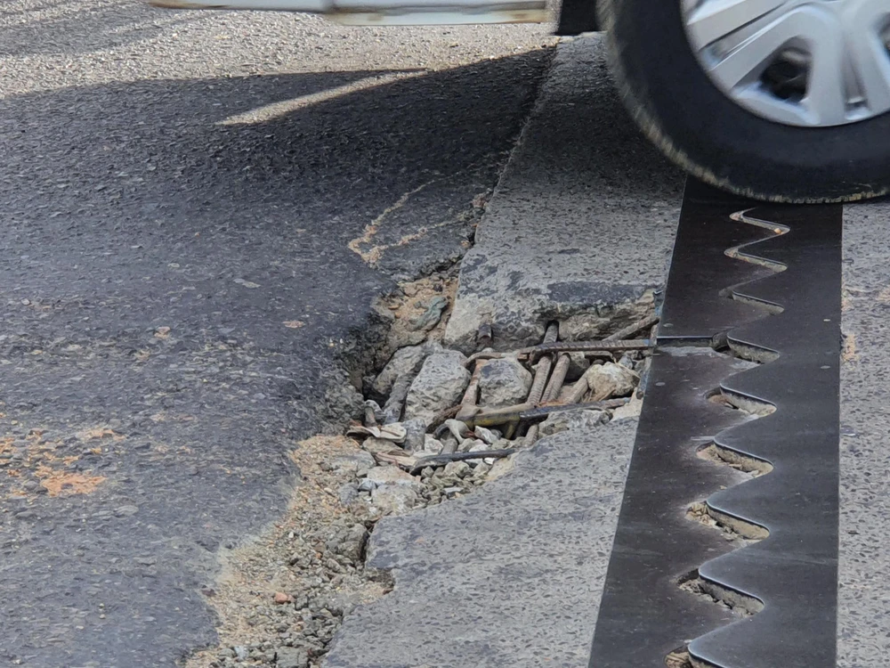 Đoạn ngang qua cầu xuất hiện một vết hư hỏng lớn, sắt và bê tông lồi ra. Ảnh QN