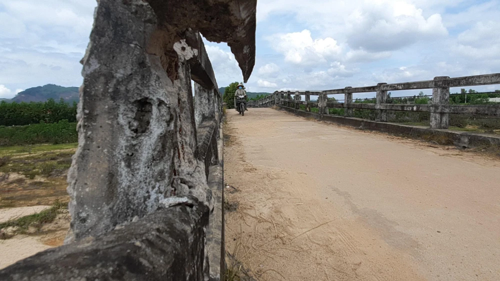 Nhiều người dân vẫn phải mạo hiểm đi qua cầu Bình Long mặc dù vẫn biết là rất nguy hiểm. Ảnh QN