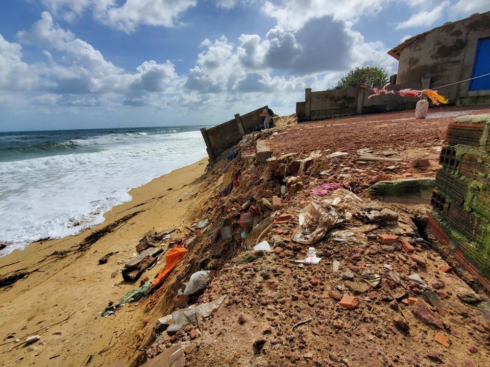 Sạt lở bờ biển ngay sát nhà dân. Ảnh QN