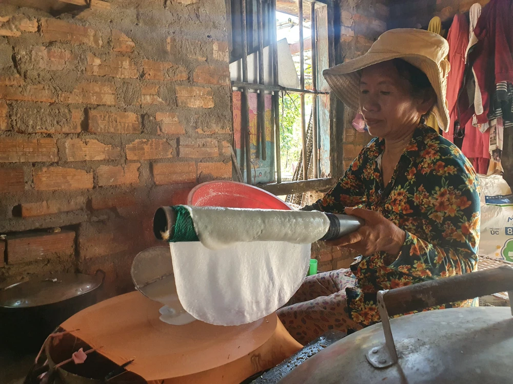 Bà Nguyễn Thị Hoa (65 tuổi) là một số ít người tráng bánh thủ công. Ảnh QN