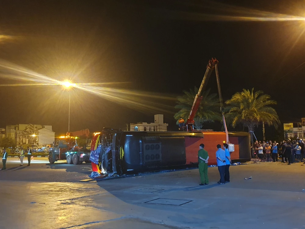 Xe khách bị lật sau cú va chạm với xe tải. Ảnh QN