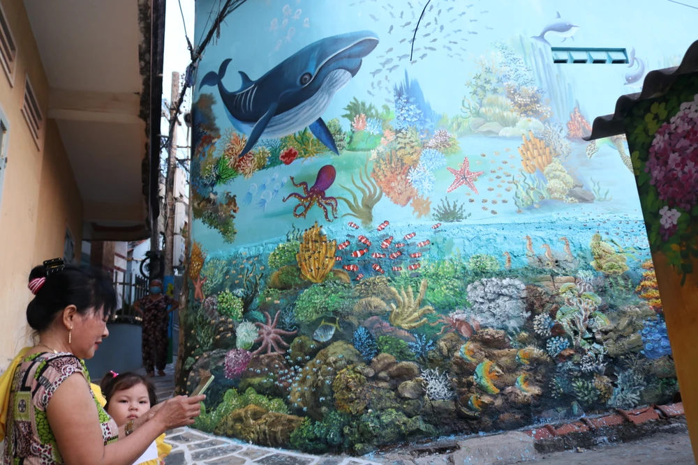 Việc vẽ tranh bích họa trên các con đường ở xã Nhơn Lý được thực hiện theo đề án phát triển du lịch cộng đồng của tỉnh Bình Định nói chung, thu hút khách du lịch đến với làng chài Nhơn Lý nói riêng. Ảnh QN