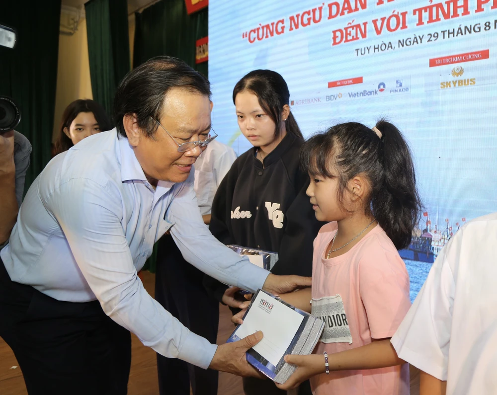 Tổng Biên tập báo Pháp luật TP.HCM Mai Ngọc Phước tặng học bổng cho học sinh. Ảnh: HOÀNG GIANG