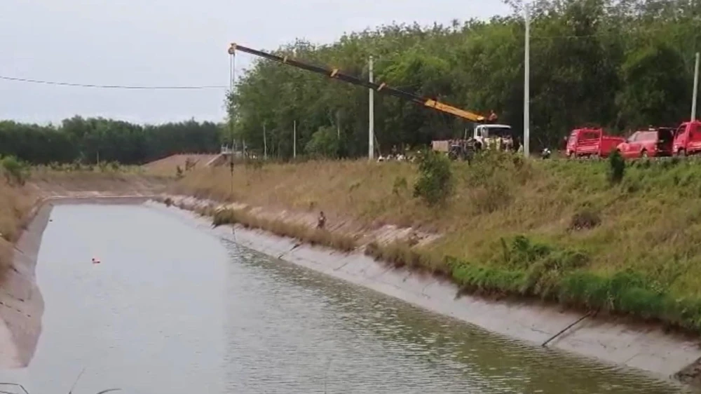 Lực lượng chức năng vớt thi thể và chiếc máy cày bị rơi xuống kênh. Ảnh: Người dân cung cấp