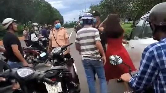 Khi lực lượng cảnh sát giao thông áp sát, cô gái (váy đỏ) mới chịu dừng xe. Ảnh: Cắt từ clip