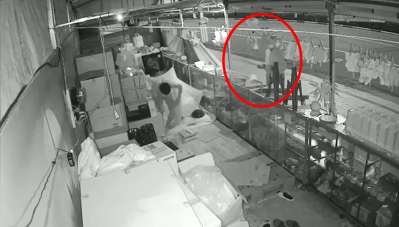 Nhân cầm mã tấu đe dọa nhân viên yêu cầu đưa bánh trung thu. Ảnh: Cắt từ camera