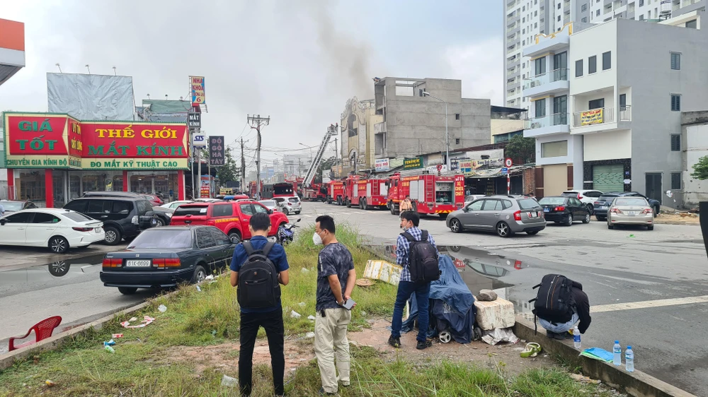 Đám cháy đang bùng phát trở lại, lực lượng chữa cháy đang nỗ lực để vừa dập lửa vừa tìm kiếm các nạn nhân. Ảnh: LÊ ÁNH