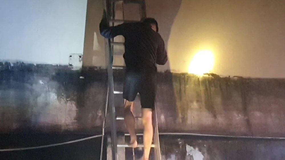Người dân bị mắc kẹt trên nóc quán karaoke được lực lượng công an hỗ trợ đưa xuống an toàn, một số người khác do quá hoảng loạn đã nhảy từ trên cao xuống bị thương. Ảnh: LA