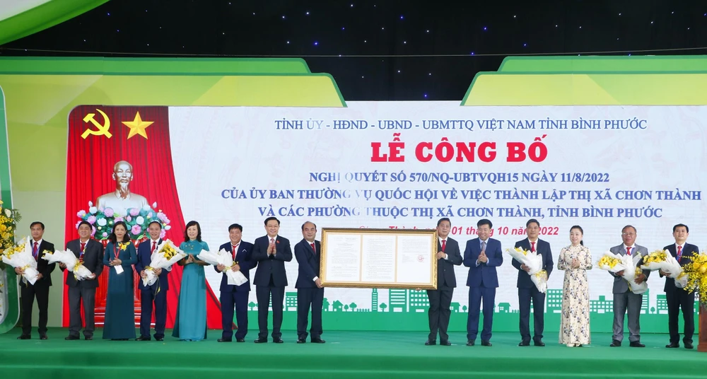 Chủ tịch Quốc hội Vương Đình Huệ trao Nghị quyết và chúc mừng chính quyền, nhân dân thị xã Chơn Thành. Ảnh: LÊ ÁNH