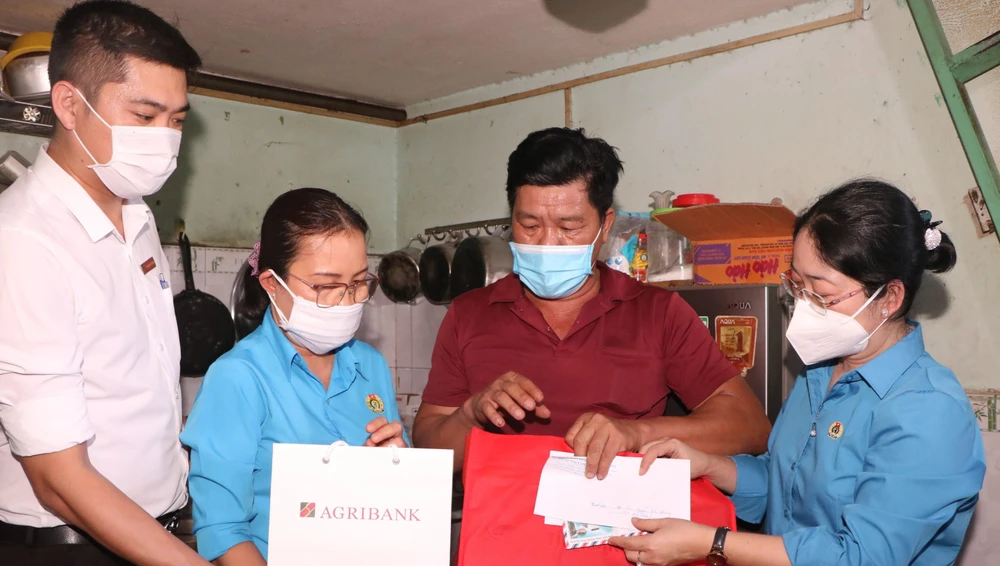 Bà Nguyễn Kim Loan, Chủ tịch Liên đoàn lao động tỉnh Bình Dương (phải) tặng quà cho công nhân có hoàn cảnh khó khăn. Ảnh: ĐT