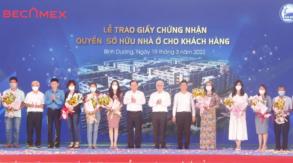 Lãnh đạo tỉnh Bình Dương trao sổ hồng các căn NƠXH cho người dân. Ảnh: LÊ ÁNH