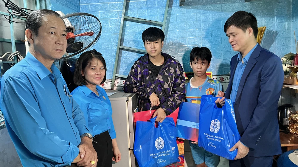 Ông Ngọ Duy Hiểu, Phó Chủ tịch Tổng Liên đoàn Lao động Việt Nam (bên phải) trao quà cho hai anh em mồ côi. Ảnh: LÊ ÁNH