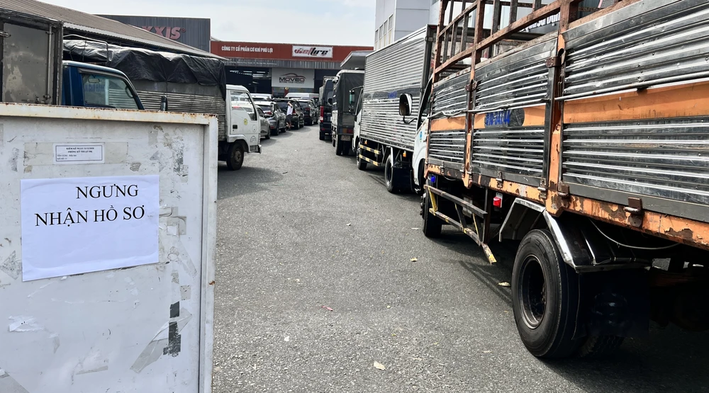 Các phương tiện nối đuôi nhau, xếp hàng dài trước Trung tâm đăng kiểm xe cơ giới 61-01S nằm trên Đại lộ Bình Dương (TP Thủ Dầu Một), bảng ngưng nhận hồ sơ đã được đặt trước cổng từ buổi sáng. Ảnh: LÊ ÁNH