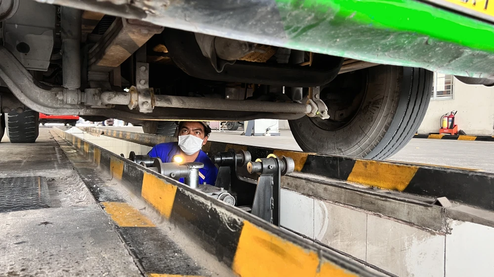 Các kiểm định viên tại Trung tâm đăng kiểm xe cơ giới 61-03S làm việc hết công suất, tăng ca nhưng vẫn không đáp ứng được nhu cầu. Ảnh: LÊ ÁNH