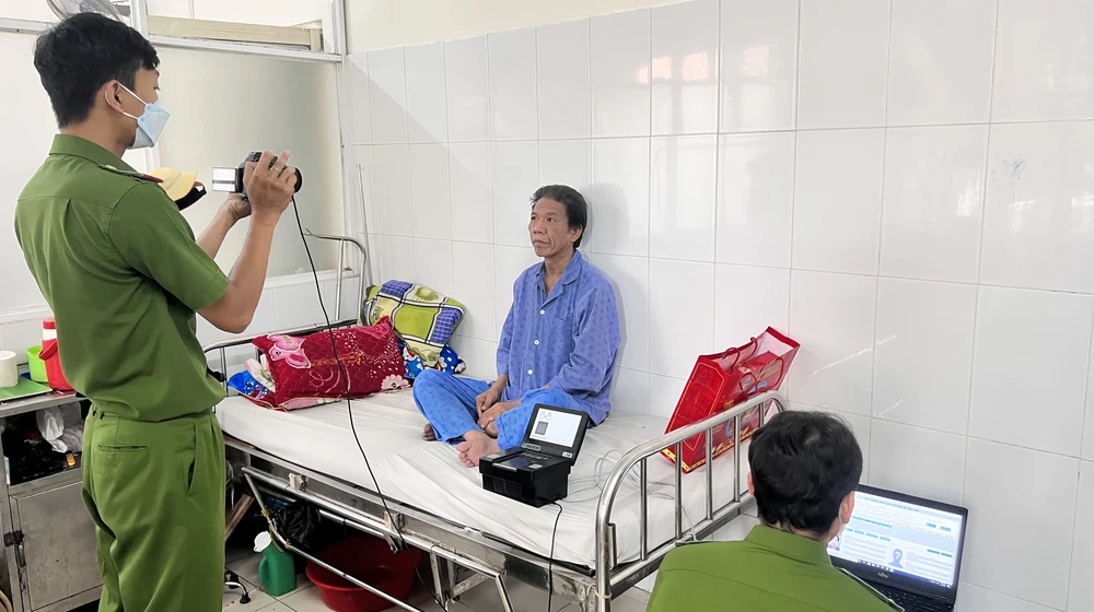 Lực lượng công an kích hoạt tài khoản định danh điện tử và tích hợp thẻ BHYT vào CCCD cho người bệnh. Ảnh: LÊ ÁNH