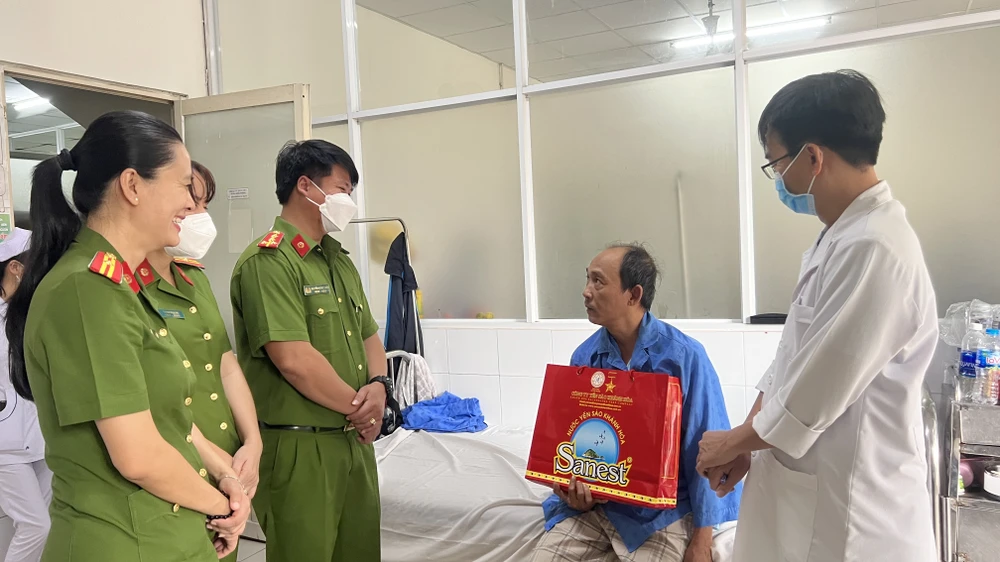 Cán bộ chiến sĩ Phòng Cảnh sát QLHC về TTXH, Công an tỉnh Bình Dương, đến tận giường bệnh trao quà Tết cho người bệnh. Ảnh: LÊ ÁNH