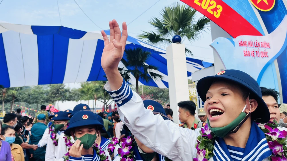 Tân binh vẫy chào người thân khi chuẩn bị lên xe về với đơn vị.