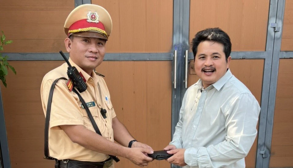 Đại diện tổ tuần tra trao trả ví tiền cho người dân.