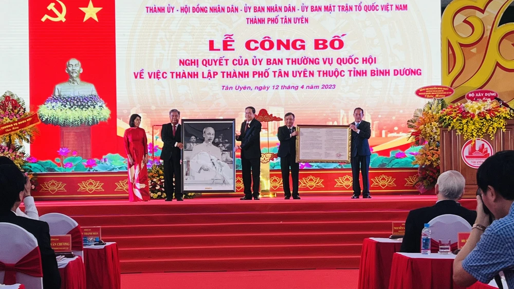 Phó Chủ tịch Thường trực Quốc hội Trần Thanh Mẫn trao Nghị quyết cho lãnh đạo TP Tân Uyên. Ảnh: LÊ ÁNH Phó Chủ tịch Thường trực Quốc hội Trần Thanh Mẫn trao Nghị quyết cho lãnh đạo TP Tân Uyên. Ảnh: LÊ ÁNH