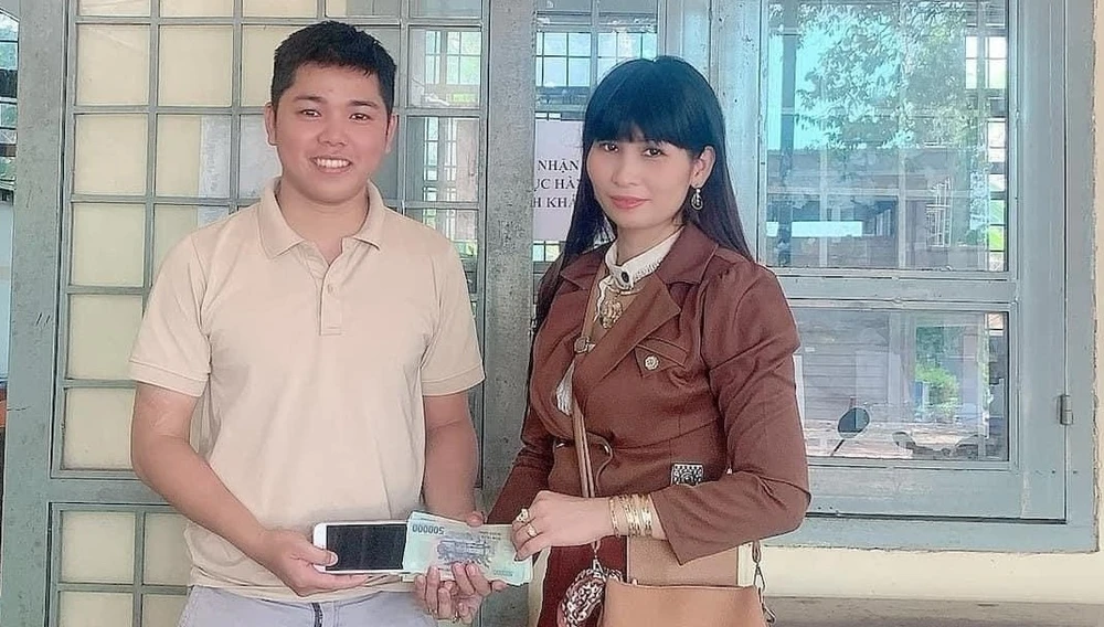 Anh Khánh trao trả túi xách cho chị Nguyễn Thị Vân. Ảnh: LA