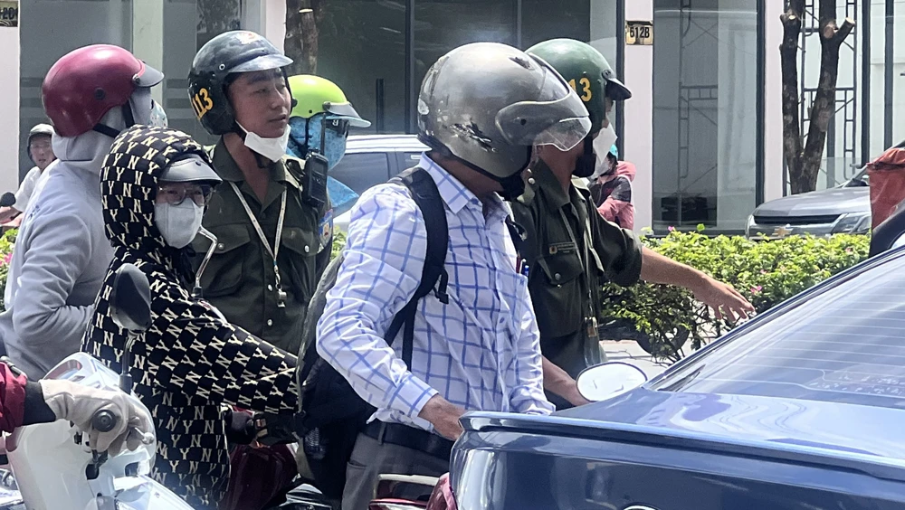 Khi bị lực lượng chức năng nhắc nhở, người đàn ông phản ứng vì ai cũng đứng như mình. Ảnh: LÊ ÁNH