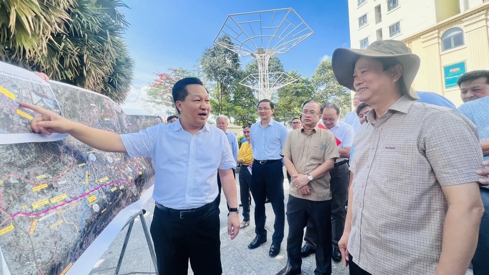 Lãnh đạo hai địa phương đi khảo sát các nút giao thông của các dự án sắp triển khai. Ảnh: LÊ ÁNH