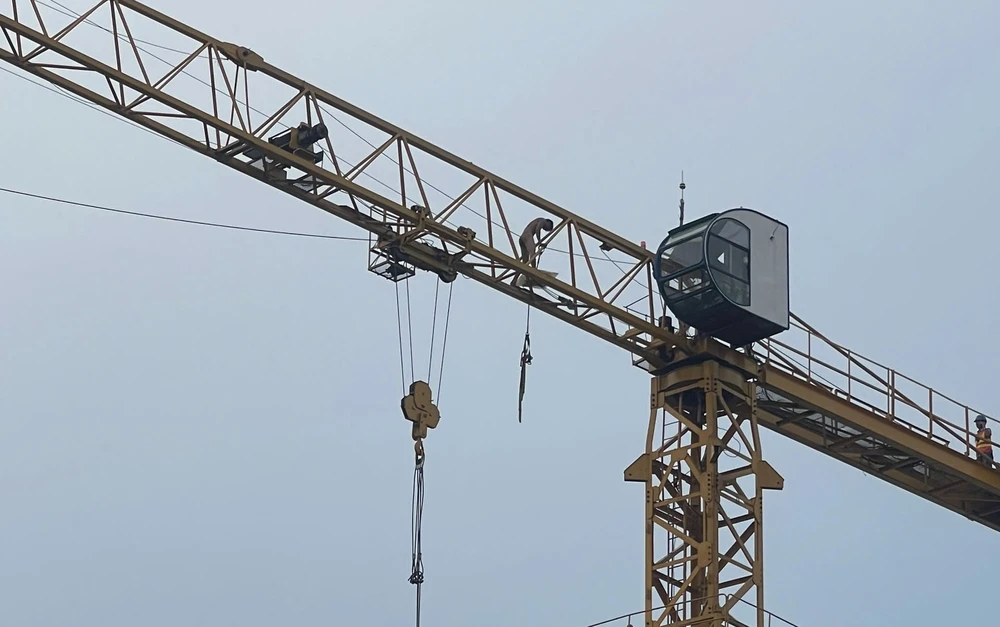 Người đàn ông không mặc quần áo đi lại trên cần cẩu cao hàng chục mét