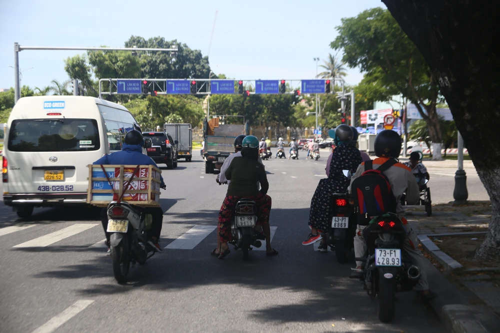 Người dân trnh thủ bóng cây mát để chờ đèn đỏ.