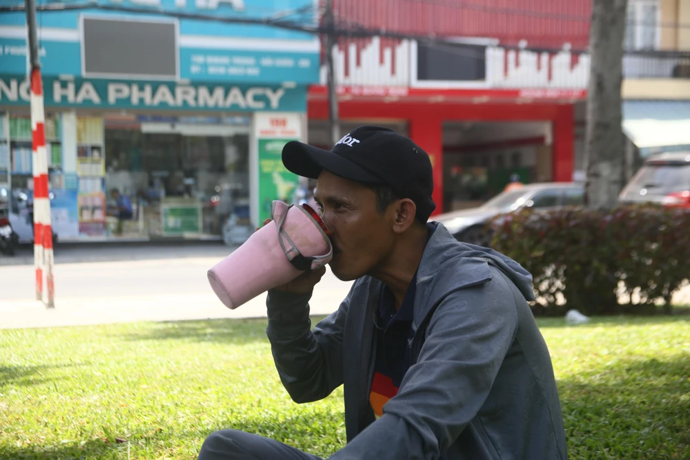 Anh Đạt đang nghỉ ngơi, tiếp nước giữa trưa cạnh công viên.
