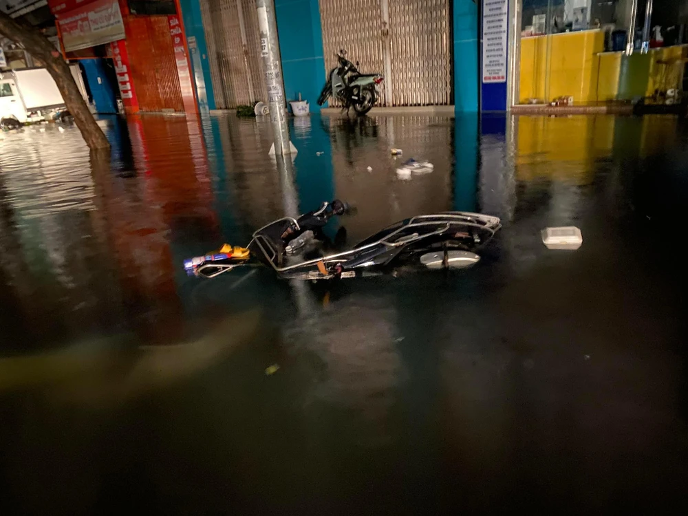 Người dân bỏ lại xe máy giữa dòng lũ. Ảnh: HH.