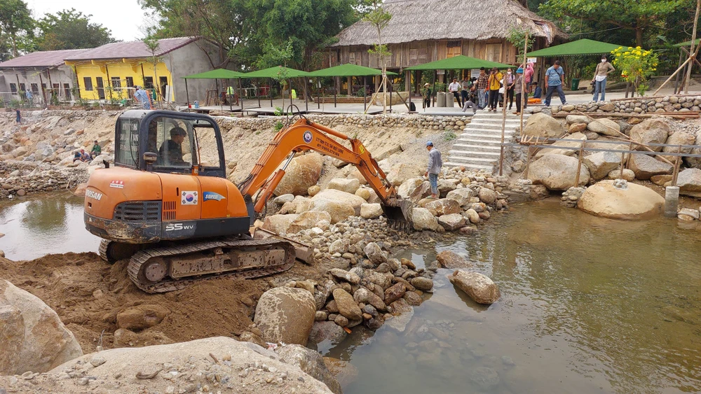 Máy xúc phá dỡ phần chặn dòng suối Lương. Ảnh: NT