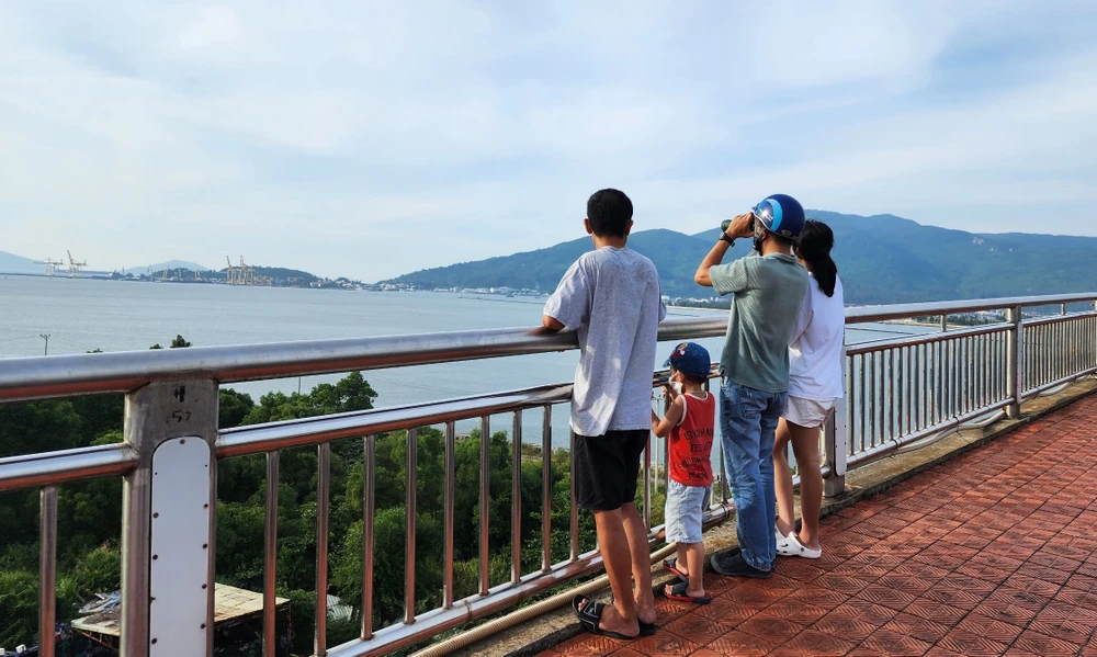 Trẻ em cùng cha mẹ lên cầu Thuận Phước ngắm tàu sân bay Mỹ. Ảnh: MT.