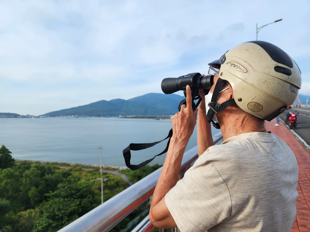 Người dân thích thú dùng ống nhòm ngắm tàu sân bay Mỹ. Ảnh: MT.