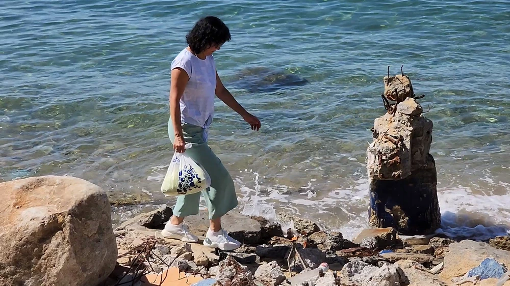 Du khách bước qua bãi bê tông cốt thép trên bờ biển bán đảo Sơn Trà.