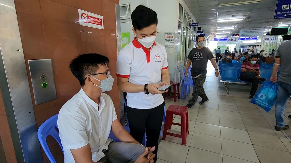 Các tình nguyện viên hướng dẫn người hiến máu kê khai thông tin trên điện thoại thông minh.