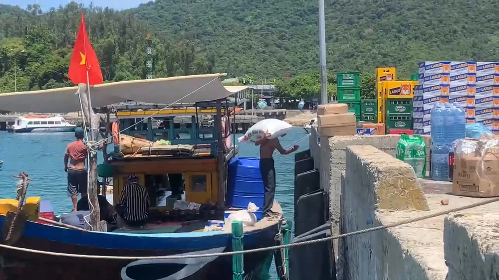 Người dân bốc hàng từ tàu cá lên đảo phục vụ người dân, du khách. Ảnh: MT.