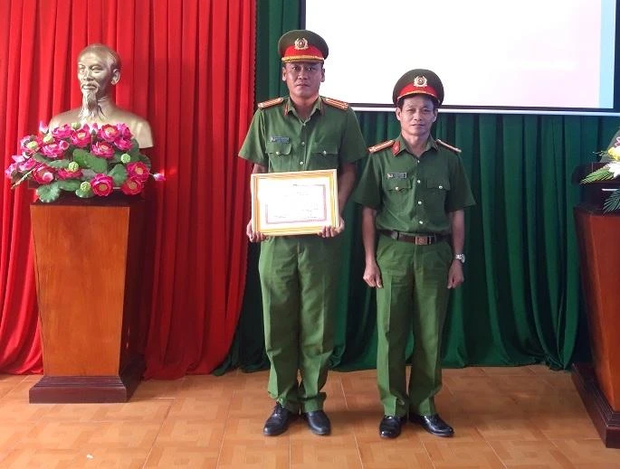 Thượng tá Lương Văn Tâm - Trưởng Công an huyện Cao Lãnh (phải) trao giấy khen cho Trung tá Nguyễn Trọng Hiếu.