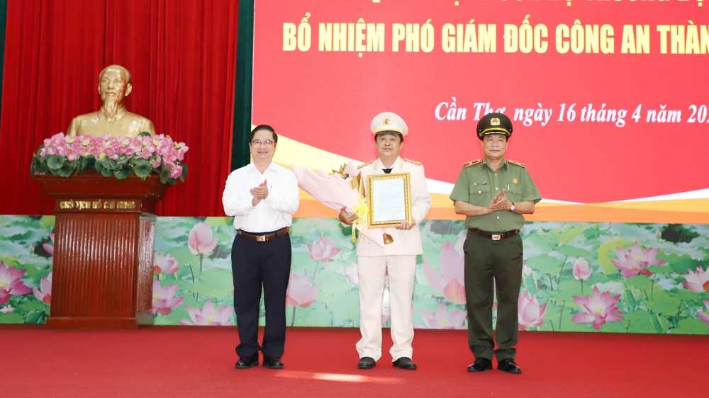 Ông Trần Việt Trường, Chủ tịch UBND TP Cần Thơ và Thiếu tướng Nguyễn Văn Thuận, Giám đốc Công an TP Cần trao quyết định và hoa chức mừng Thượng tá Lê Đức Bảy . Ảnh: HD