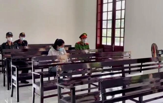 Chị H. ôm con nhỏ mới sinh đến dự phiên toà xét xử mẹ, chồng và em trai. Ảnh: HD