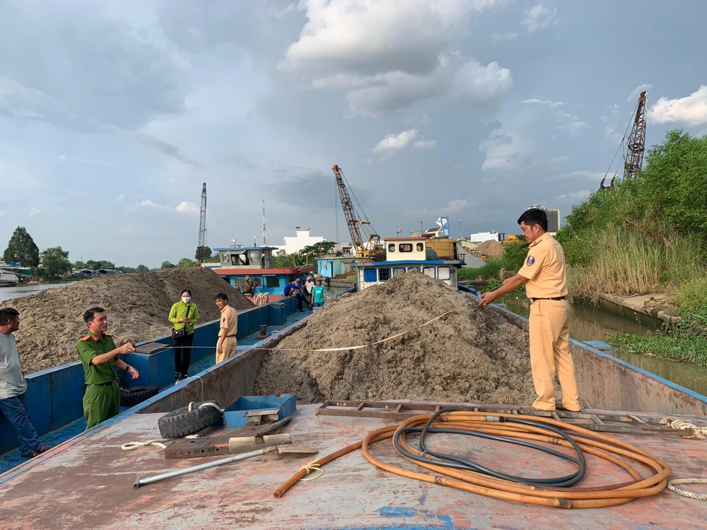 Lực lượng chức năng ghi nhận, lập biên bản tạm giữ phương tiện cùng số cát không rõ nguồn gốc. Ảnh: CACC