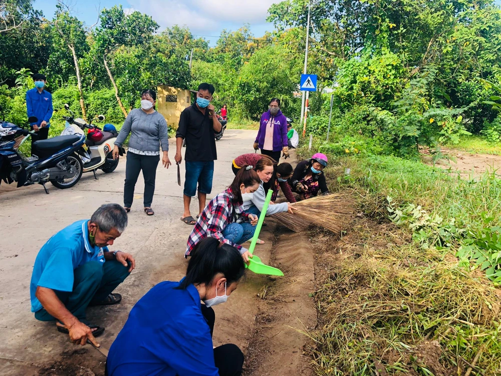 Người dân cùng vệ sinh môi trường, phát quang bờ bụi, úp, loại bỏ nước ở các dụng cụ chứa nước không cần thiết. Ảnh: HD