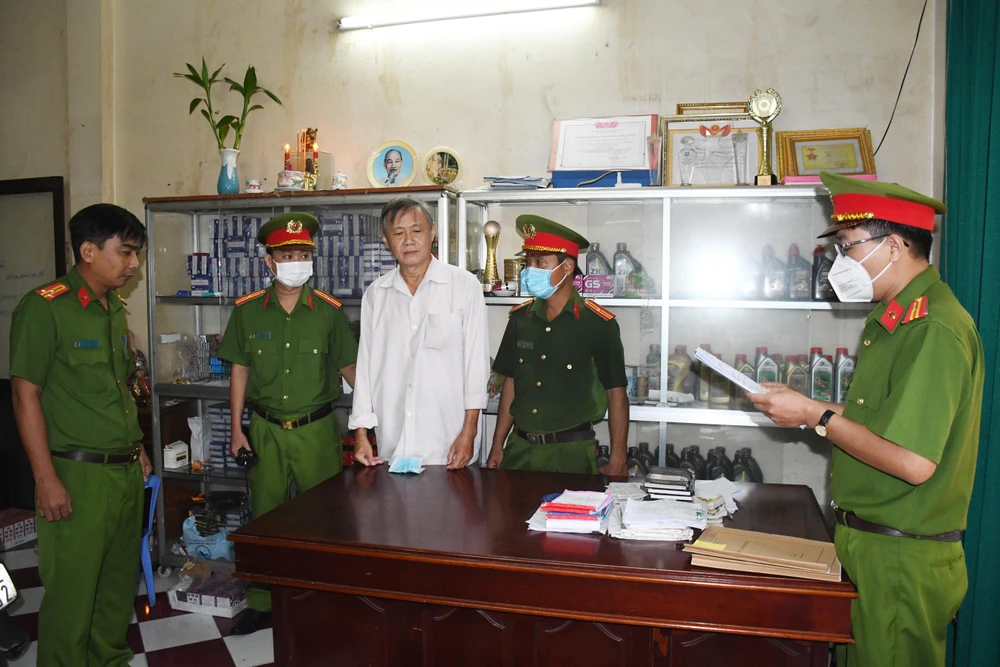 Công an đọc lệnh bắt tạm giam bị can Lê Hùng Quốc. Ảnh: HG