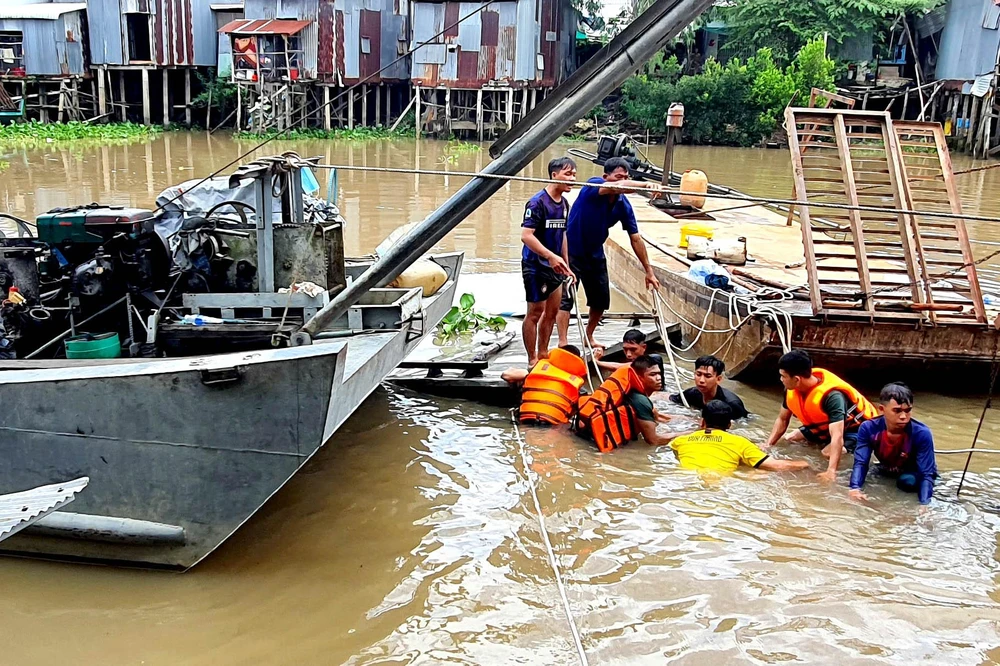 Lực lượng Bộ đội biên phòng cùng người dân trục vớt phương tiện và cây bị chìm.