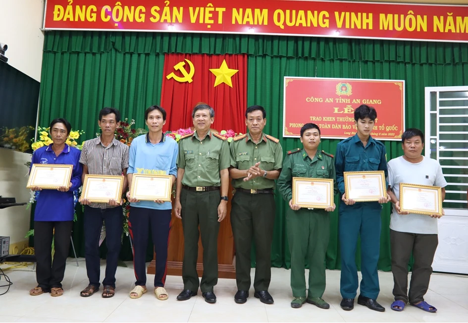 Đại tá Nguyễn Trường Viễn - Trưởng phòng Xây dựng phong trào bảo vệ ANTQ và Thượng tá Lâm Văn Tiên - Trưởng phòng Công tác đảng và Công tác chính trị trao Giấy khen cho sáu công dân. Ảnh: CACC