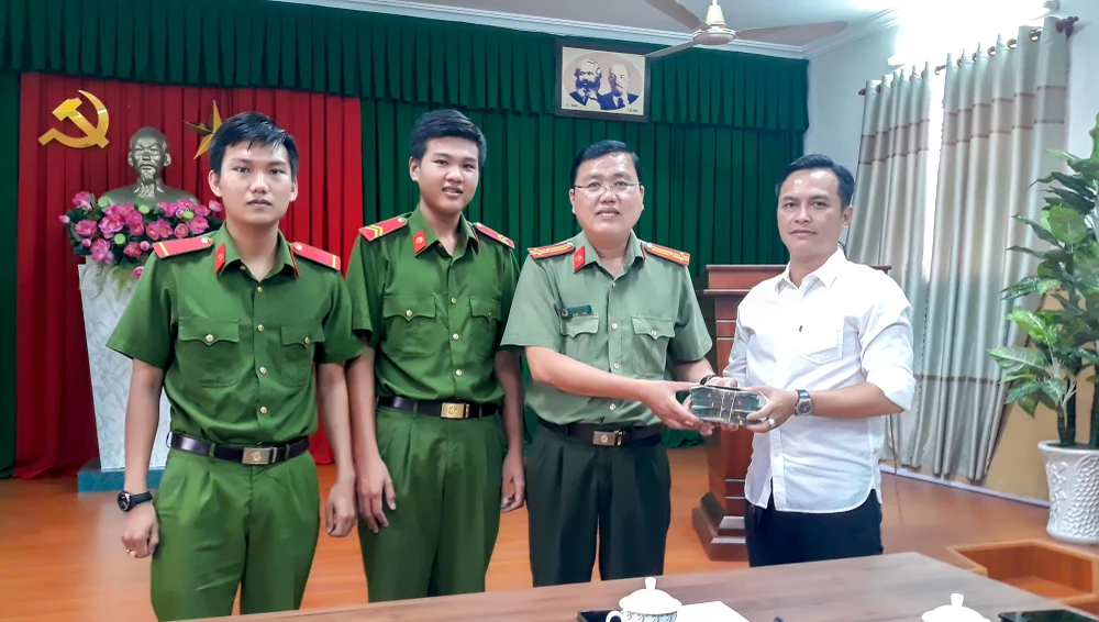 Lãnh đạo Công an TP Vĩnh Long cùng hai chiến sỹ trao trả tài sản cho người bị đánh rơi. Ảnh: CACC