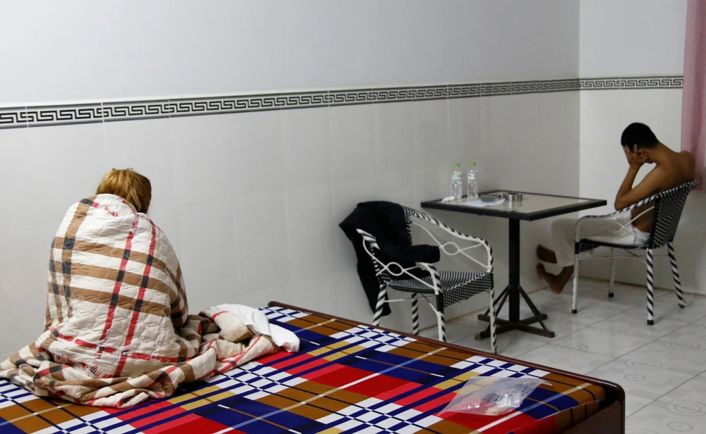 Cặp nam nữ bị bắt quả tang mua bán dâm. Ảnh: CACC