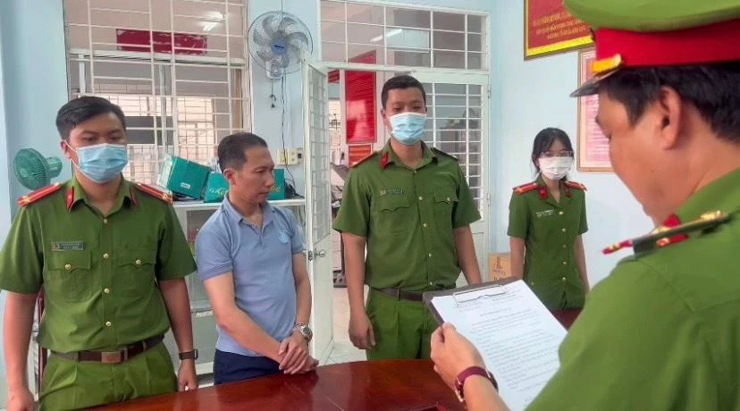 Công an tống đạt quyết định khởi tố và bắt tạm giam Vũ Xuân Tú. Ảnh: HD