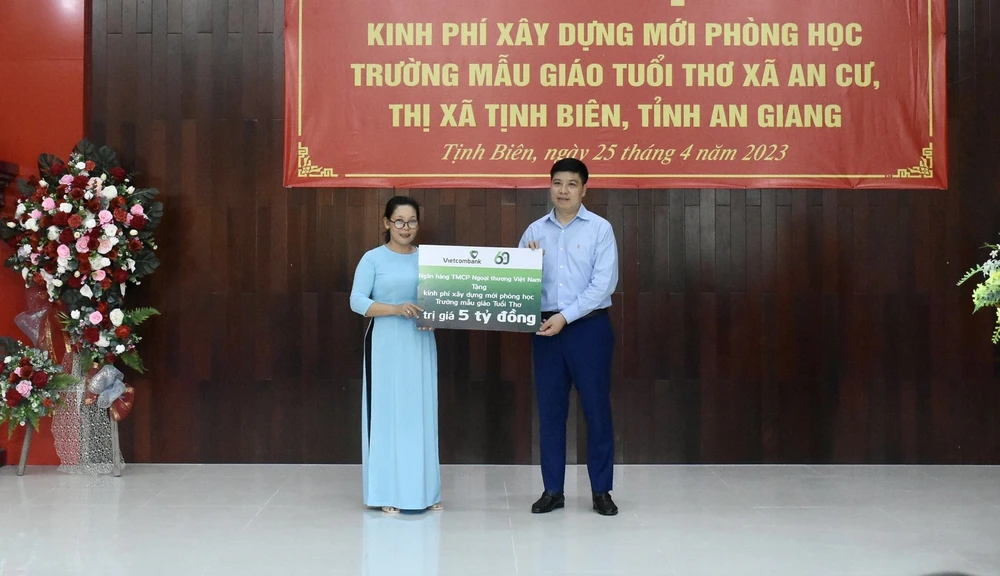 Đại diện Ngân hàng Vietcombank trao bảng tượng trưng 5 tỉ đồng cho Ban giám hiệu trường Mầm non Tuổi Thơ
